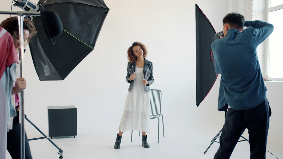 Professional photographer at work in a studio composing shots with controlled lighting equipment and camera